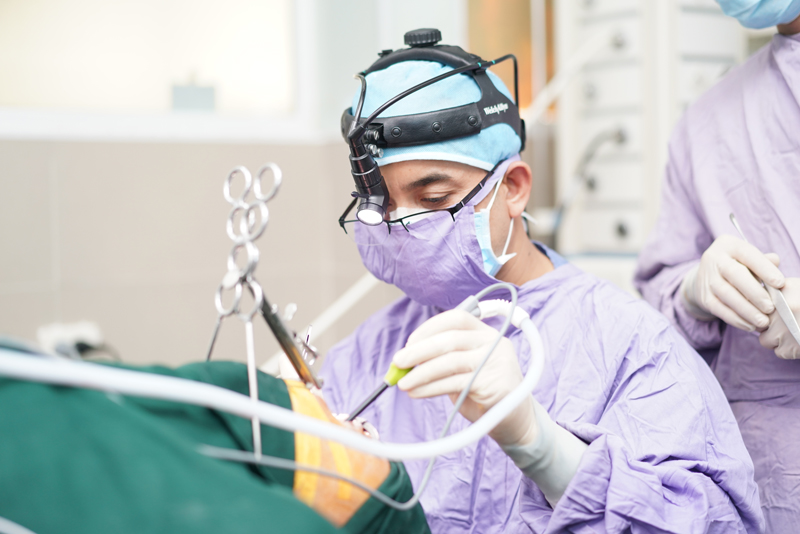 Bác sĩ phẫu thuật cắt amidan cho người bệnh